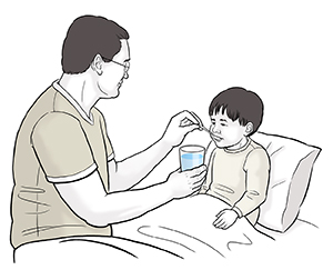 Un homme donne des cuillerées d'eau à un enfant malade dans son lit.